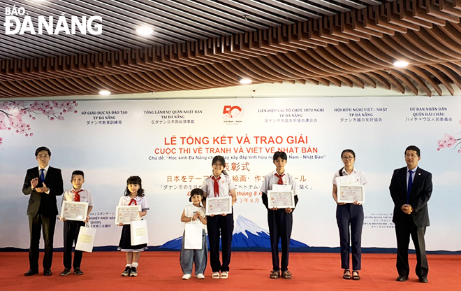 Vice Chairman of the Da Nang People's Committee Tran Chi Cuong (first, left) awards the first prize to outstanding pupils in the contest. Photo: X.D