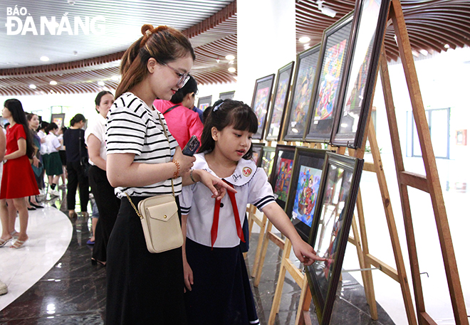 Visitors admire the prize-winning pictures in the contest. Photo: X.D