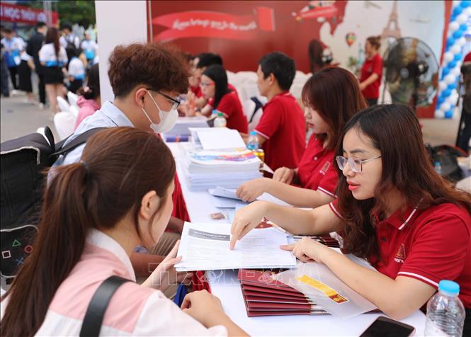 Thí sinh và phụ huynh chăm chú lắng nghe ban tư vấn của các trường giải đáp thông tin lựa chọn nguyện vọng xét tuyển. Ảnh: Thanh Tùng/TTXVN