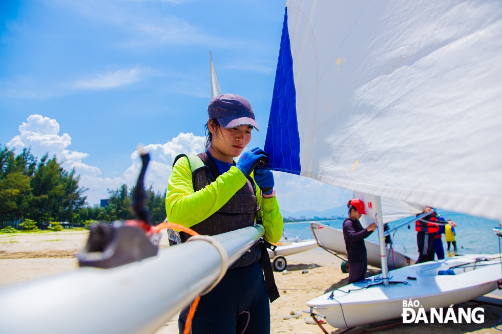 Sailing athletes prepare for their performances in the midday sun