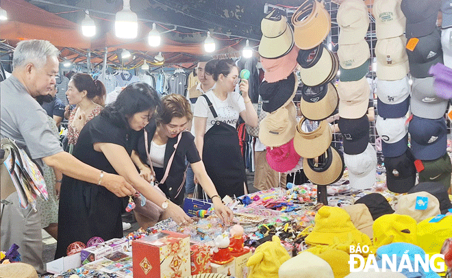 Các hoạt động về đêm tại Đà Nẵng đang dần thu hút khách. Trong ảnh: Du khách mua sắm tại chợ đêm Sơn Trà. Ảnh: THU HÀ	