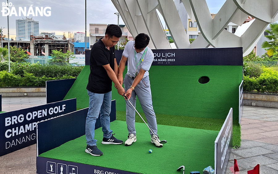 Visitors enjoy playing golf at the second floor of the APEC Statue Garden Park. Photo: THU HA