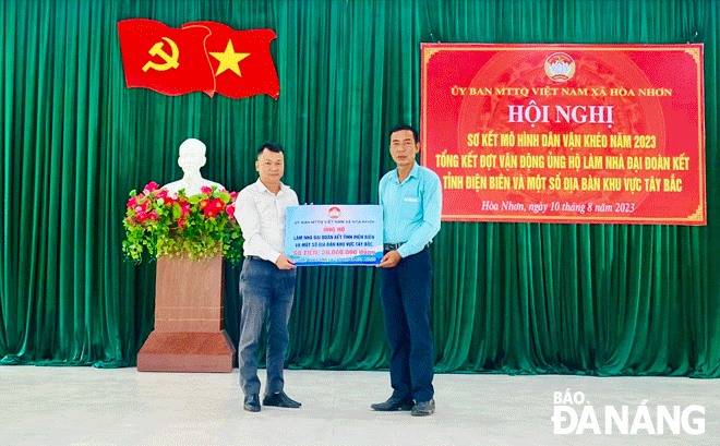 Mr Nguyen Dinh Thu (right) handing symbolic board of housing donation to a poor family in the northern province of Dien Bien. Photo: H.N