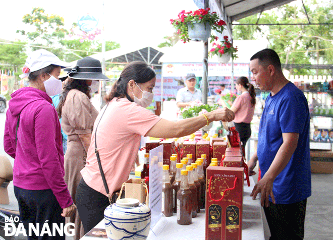 Locals and tourists buy Nam O fish sauce products at the farmers market in Hoa Vang District