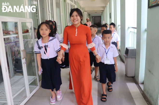 A teacher of the Thanh Khe District-based Tran Cao Van Primary School leads her pupils to the classroom. Photo: NGOC HA