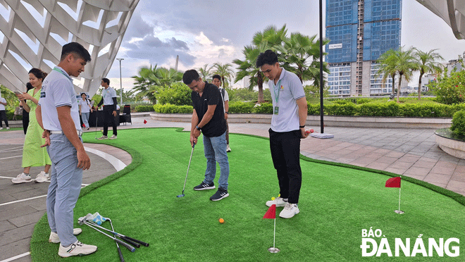 Ngành du lịch thành phố tổ chức nhiều hoạt động, sự kiện phục vụ người dân và du khách. Trong ảnh: Du khách đang trải nghiệm đánh golf tại Công viên vườn tượng APEC. Ảnh: THU HÀ	