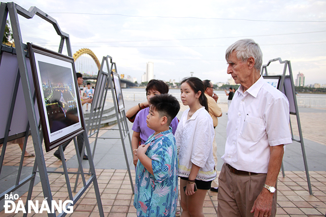 Foreign tourists and local children visit the exhibition on the afternoon of August 30. Photo: X.D