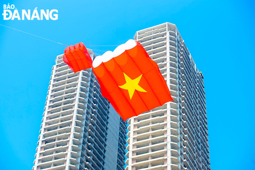  A kite highlights the shape and the colours of the country's national flag flutters over Pham Van Dong Beach