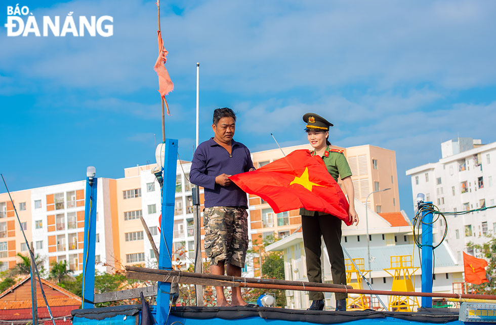  The Da Nang Police presents national flags to local fishermen.