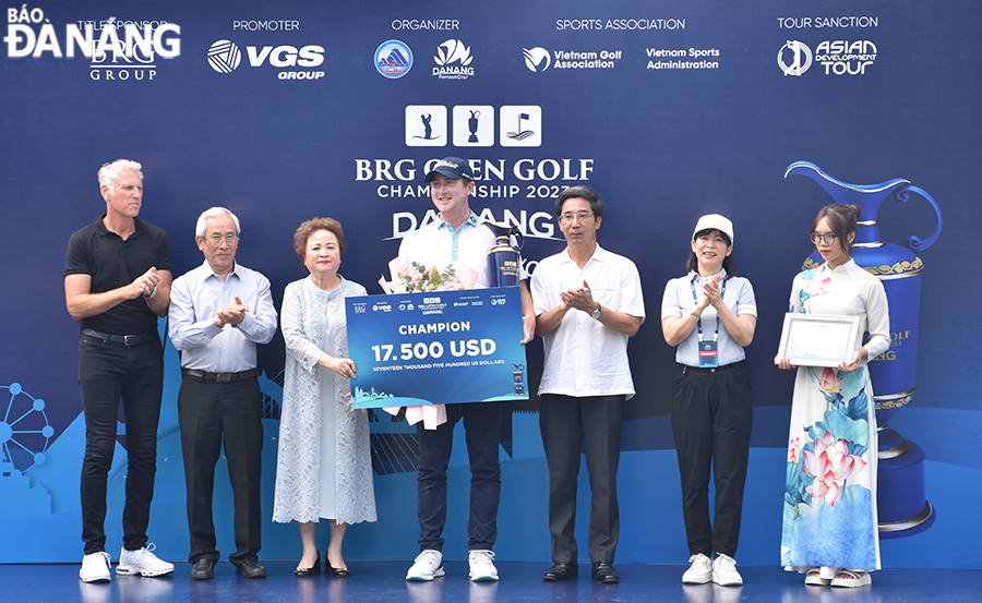 Vice Chairman of the Da Nang People's Committee Tran Chi Cuong (3rd, right), Director of the municipal Department of Tourism Truong Thi Hong Hanh (2nd, right), and Chairman of the BRG Group Nguyen Thi Nga (3rd, left)  award prize money and trophy to the tournament champion. Photo: THU HA