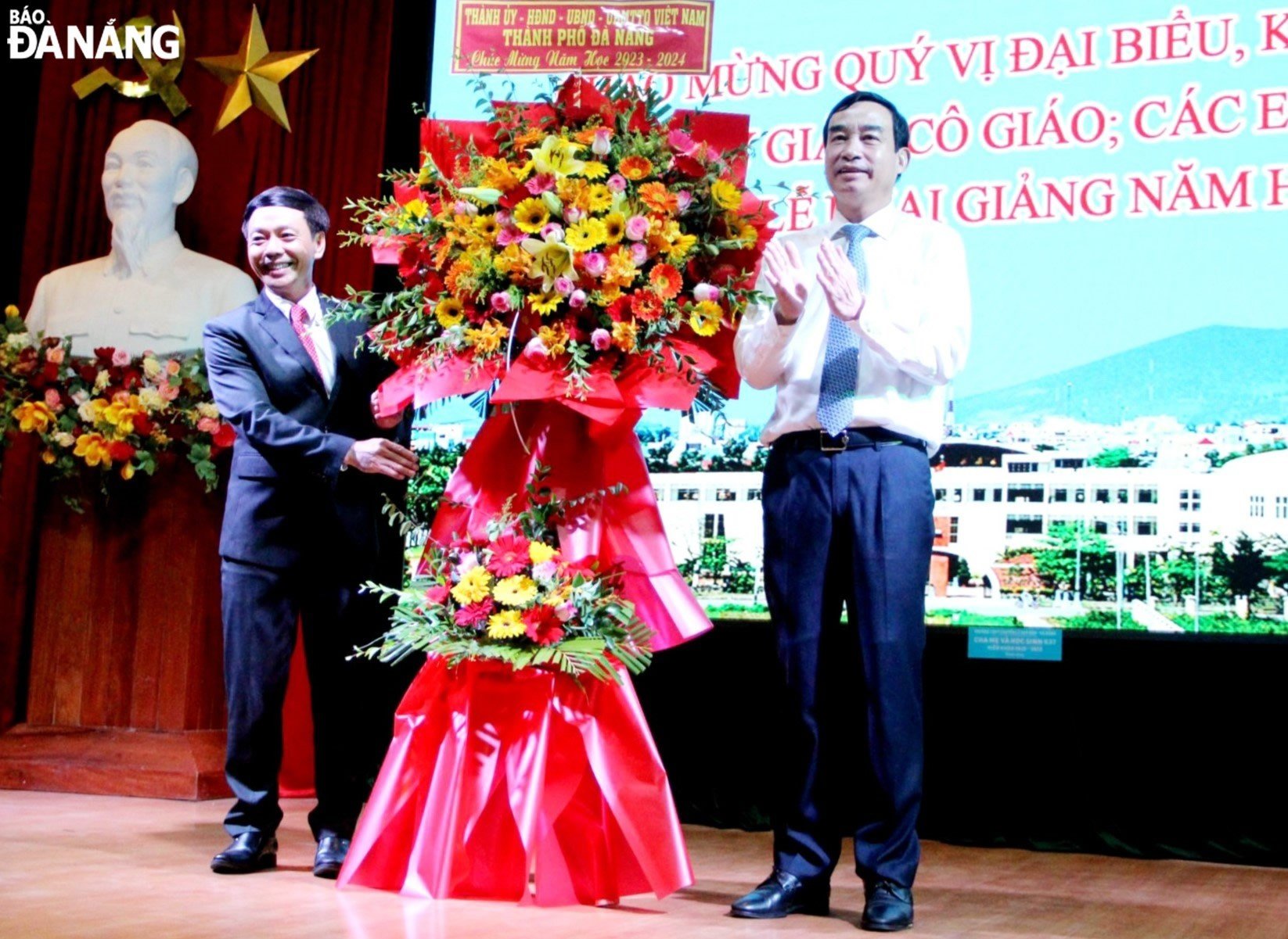Chủ tịch UBND thành phố Lê Trung Chinh (bên phải) tặng hoa chúc mừng thầy và trò Trường THPT chuyển Lê Quý Đôn. Ảnh: LÊ HÙNG