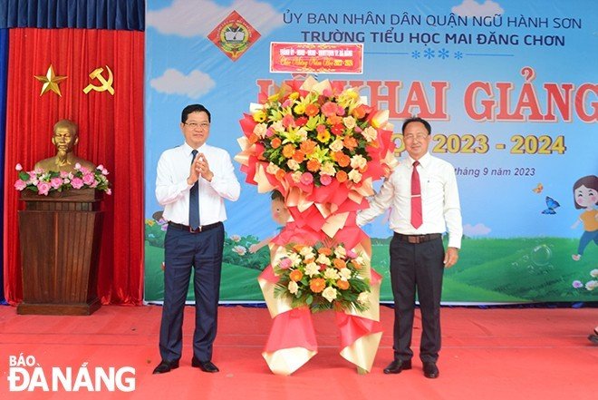 Phó Chủ tịch HĐND thành phố Trần Phước Sơn (bìa phải) tặng lẵng hoa chúc mừng Trường Tiều học Mai Đăng Chơn (quận Ngũ Hành Sơn). Ảnh: PHI NÔNG