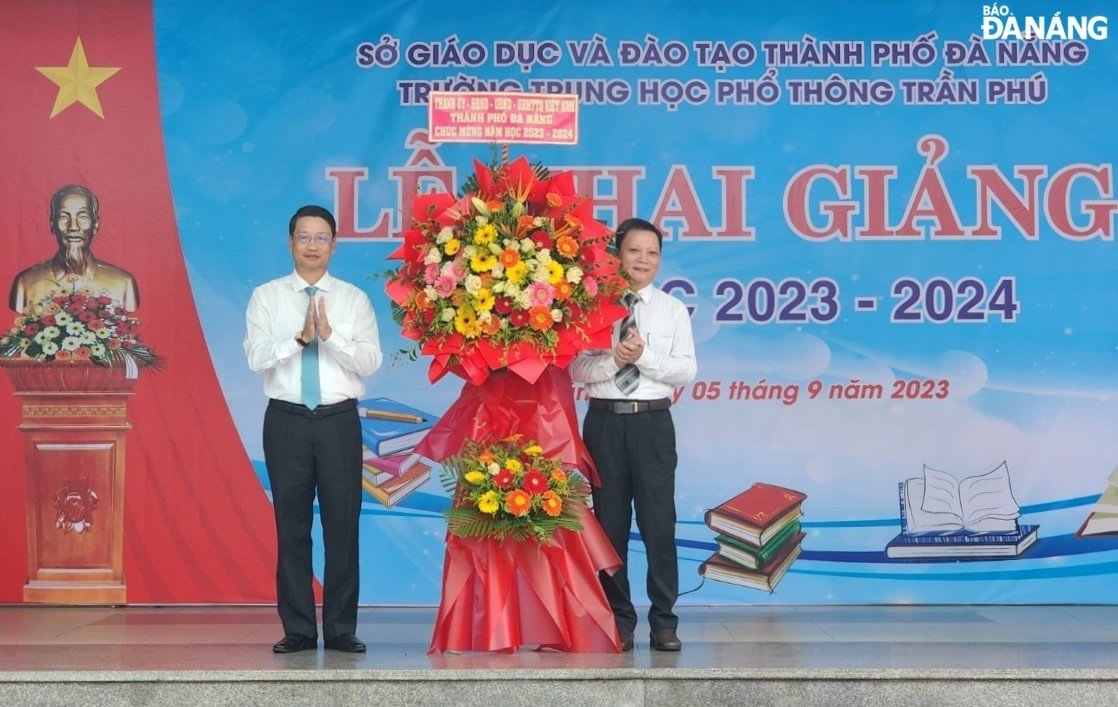 Chairman of the Viet Nam Fatherland Front Committee in Da Nang (left) presents flowers to congratulate teachers and students of the Tran Phu Senior High School. Photo: LE HUNG