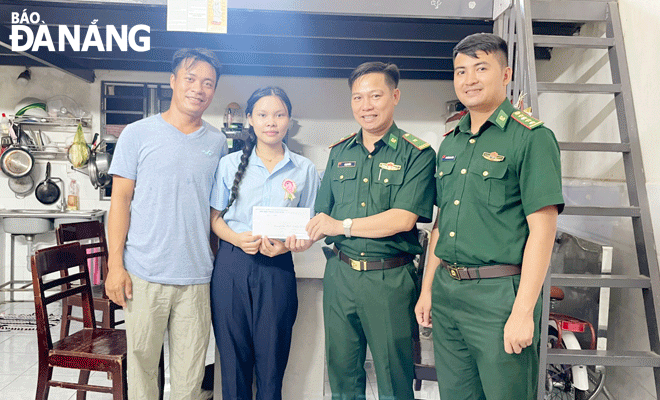 Officers and men of the Non Nuoc Border Guard Station giving a cash gifts to a poor student. Photo: KIM NGAN