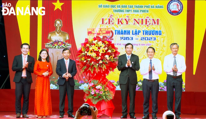 Chủ tịch UBND thành phố Lê Trung Chinh (thứ 3 từ phải sang) tặng hoa chúc mừng nhà trường. Ảnh: NGỌC HÀ