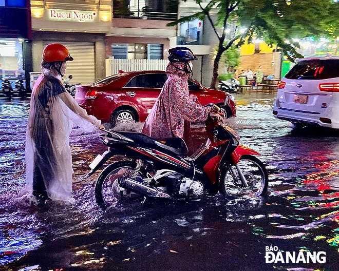 Nhiều phương tiện di chuyển trên tuyến đường Hàm Nghi bị chết máy do ngập nước.