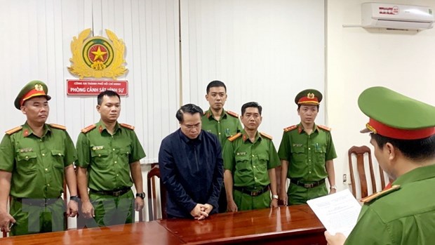 Cơ quan công an thực hiện tống đạt các Quyết định khởi tố và Lệnh bắt đối với bị can Đặng Việt Hà. (Ảnh: TTXVN phát)