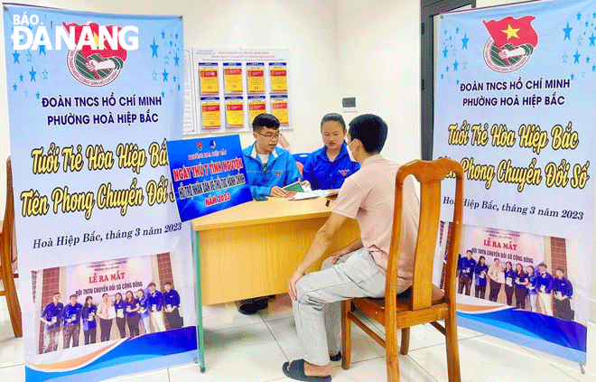 Đoàn viên thanh niên phường Hòa Hiệp Bắc (quận Liên Chiểu) hướng dẫn người dân sử dụng dịch vụ công trực tuyến. Ảnh: PV