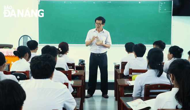 Thầy Phan Thanh Thuận hướng dẫn học sinh quan sát mô hình Bia chủ quyền Hoàng Sa khi dạy môn Toán. Ảnh: T.PHƯƠNG