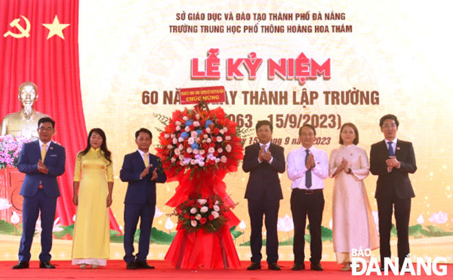 Deputy Secretary of the Da Nang Party Committee Luong Nguyen Minh Triet (4th from the right) presents congratulatory flowers to the school. Photo: NGOC HA