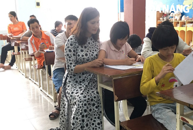 Mrs. Nguyen Thi Kim Yen teaches children who are victims of Agent Orange at the Shelter No 3 of the Da Nang Care Centre for AO Victims and Disadvantaged Children in Hoa Vang District.