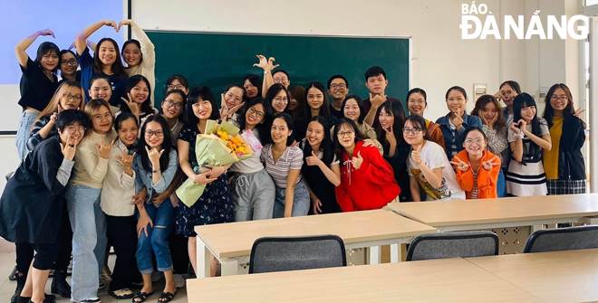 Lecturer Le Thi Tuong Vi (with flowers) and students.