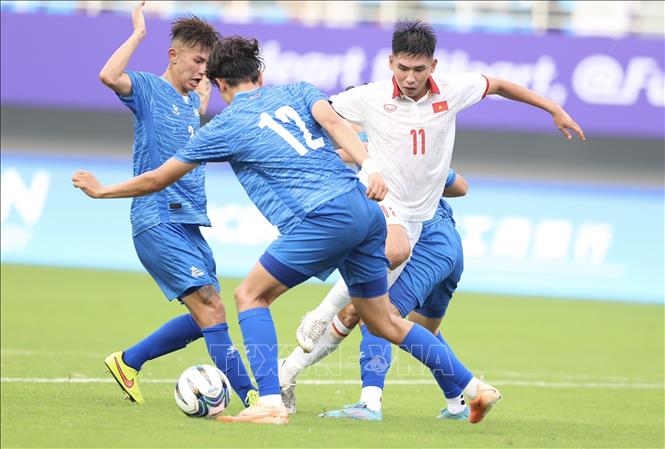 Xuân Tiến (11) đi bóng trong vòng vây 3 hậu vệ Olympic Mông Cổ. Ảnh: Hoàng Linh/TTXVN