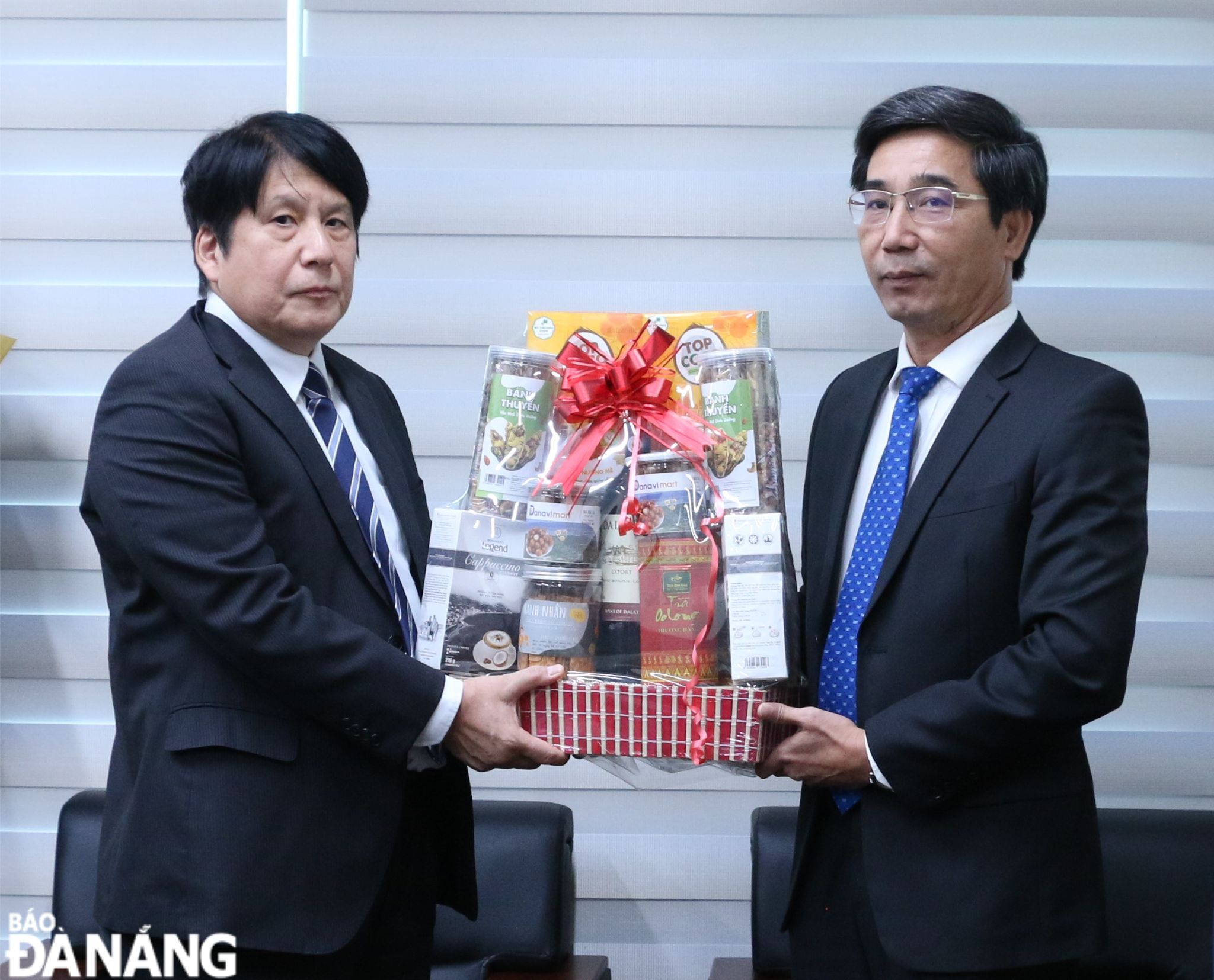 Da Nang People's Committee Vice Chairman Tran Chi Cuong (right) presenting a basket of congratulatory gift to staff of the Japanese Consulate General in Da Nang. Photo: T.PHUONG