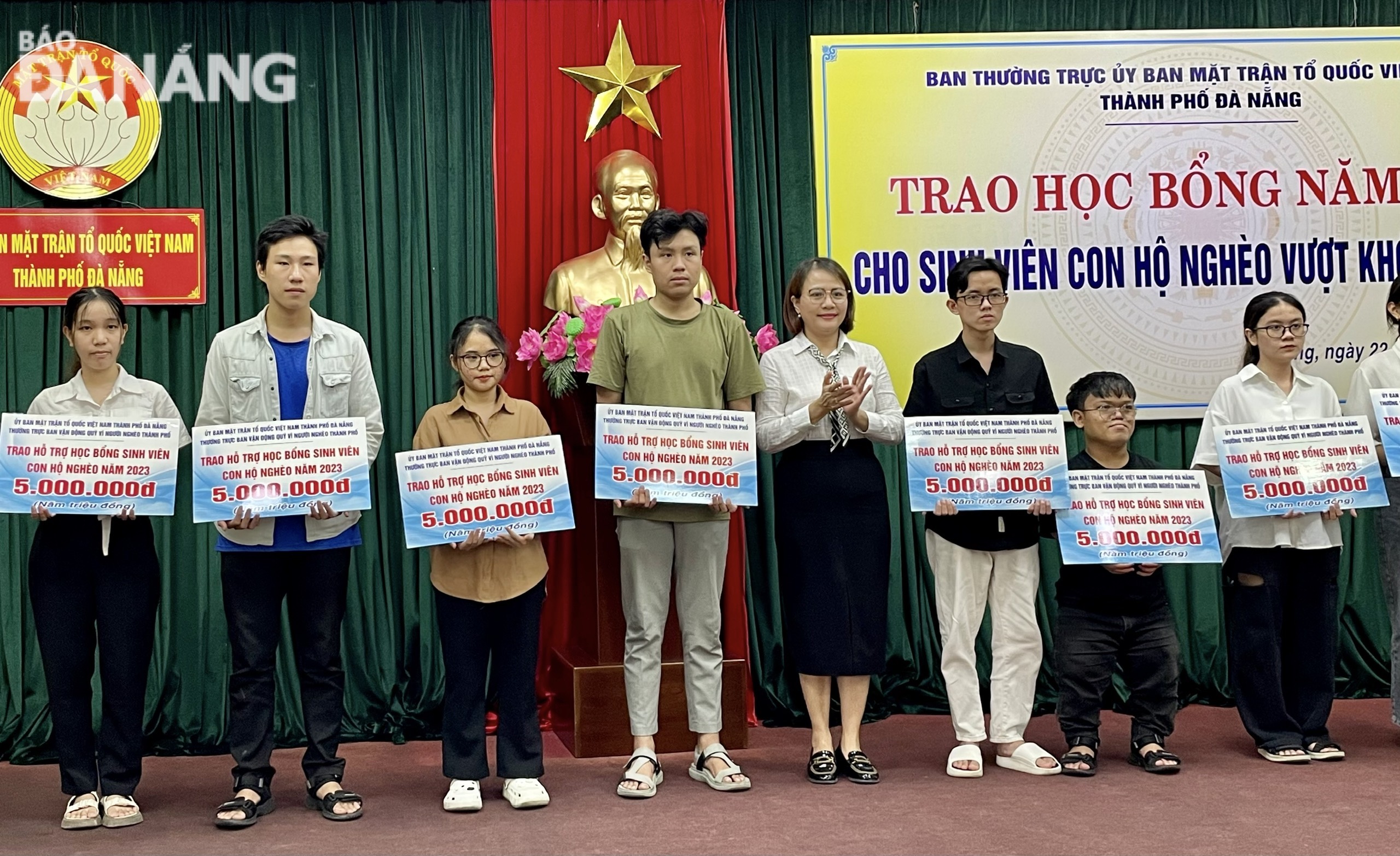 Vice Chairwoman of the Da Nang Fatherland Front Committee Tran Thi Man (5th, left) awards scholarships to students who overcome difficulties and study well. N. QUANG