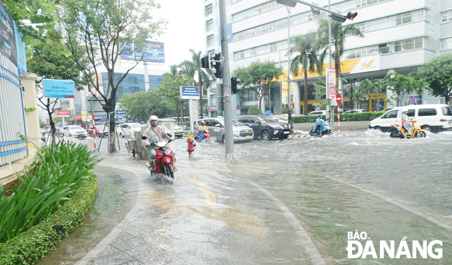 Đường Nguyễn Văn Linh còn bị ngập nước lúc 10 giờ trưa 25-9.  Ảnh: HOÀNG HIỆP