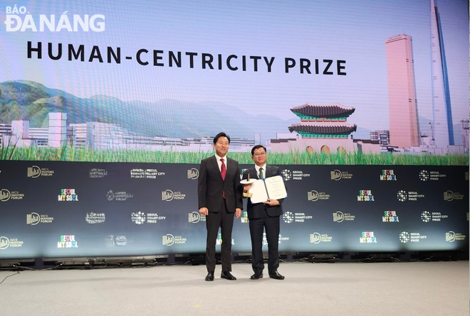 Phó Chủ tịch HĐND thành phố Trần Phước Sơn (phải) nhận giải thưởng tại Lễ trao giải thưởng Thành phố thông minh Seoul tổ chức ngày 25-9. 