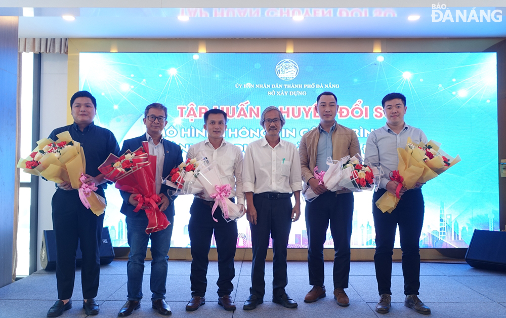 Leaders of the municipal Department of Construction present flowers to speakers and representatives of support units for the programme. Photo: HOANG HIEP