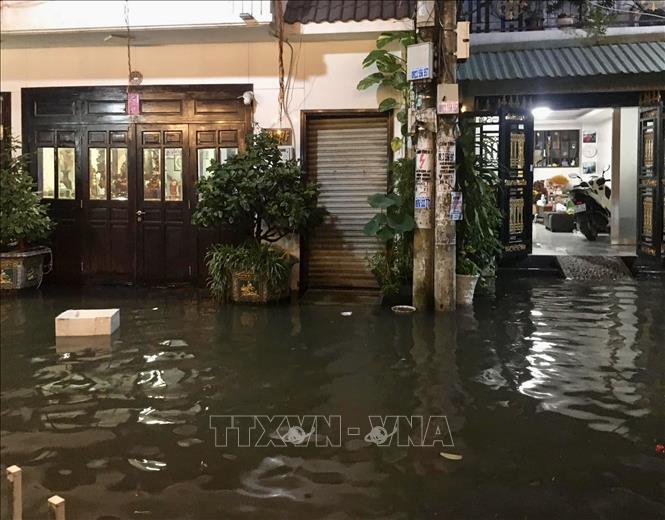 Nước ngập tràn vào nhà dân tại một tuyến hẻm trên đường Trần Xuân Soạn (Quận 7). Ảnh: Hồng Giang/TTXVN