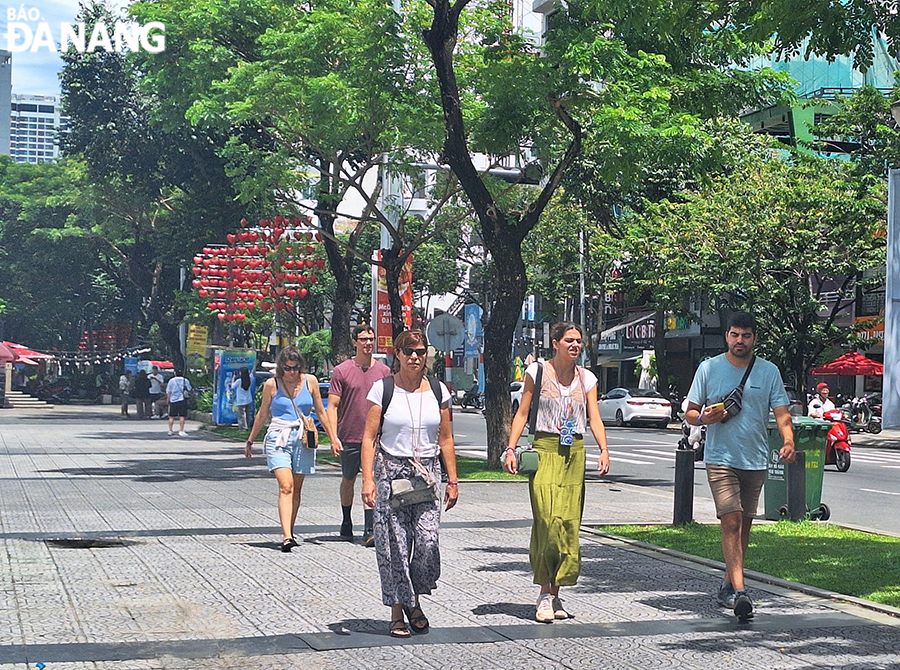 Tourists visit the Dragon Bridge and Love Bridge onTran Hung Dao Street. Photo: THU HA