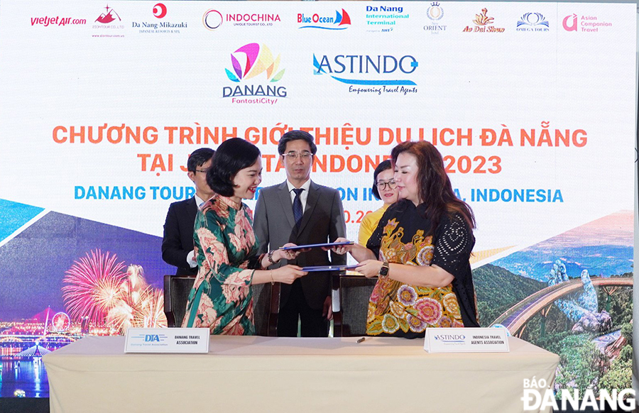 Vice Chairman of the Da Nang People's Committee Tran Chi Cuong (middle) witnesses the signing of a cooperation agreement on promoting exchange of tourist sources between Da Nang  and Indonesia Travel Associations.