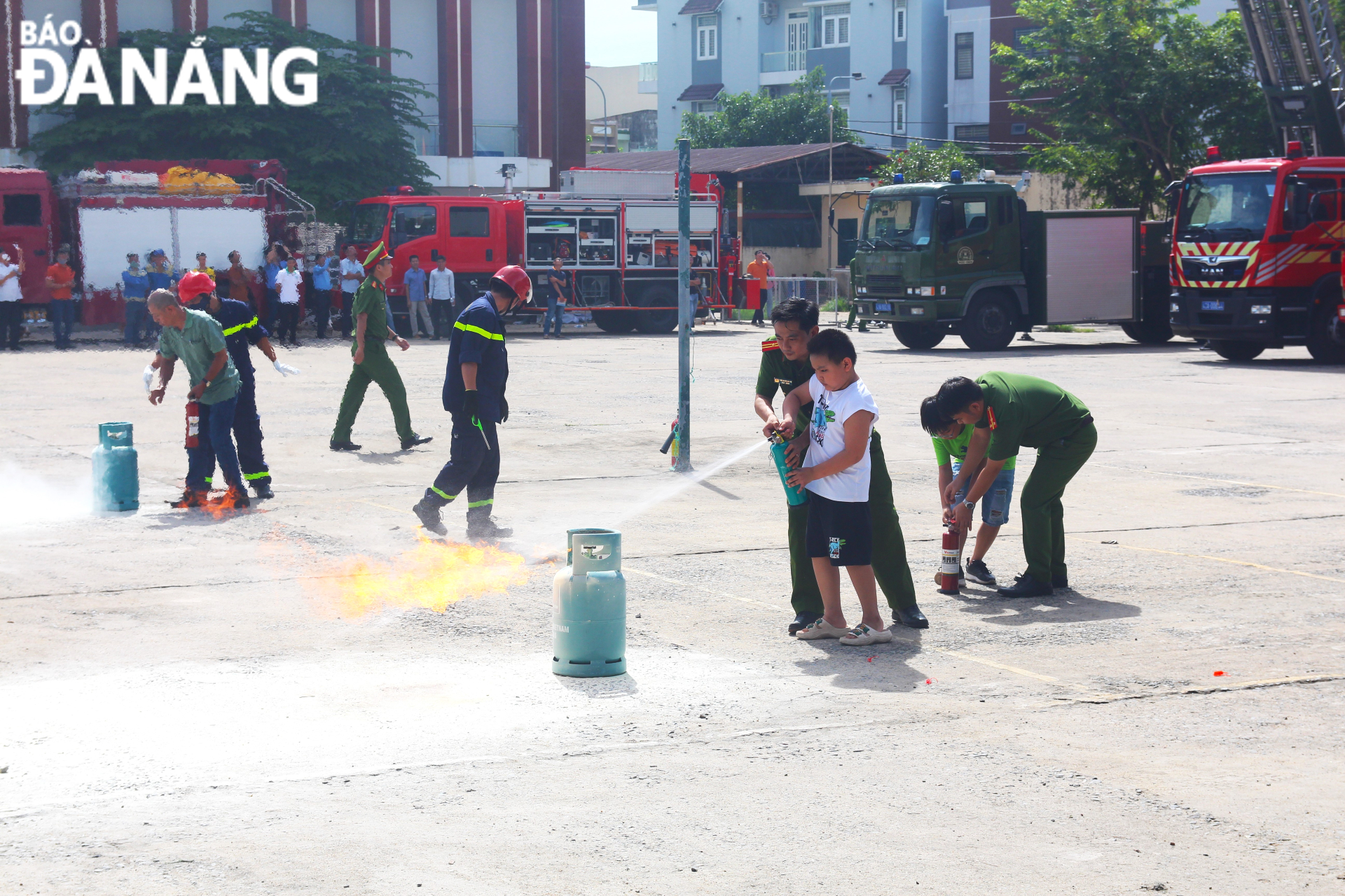 Staff of the Fire Prevention and Fighting and Rescue Police Division under the Da Nang Department of Police instruct children to practice using portable fire extinguishers to extinguish fires caused by gas leaks. Photo: N.Q