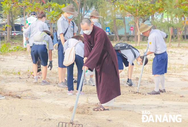 Các phật tử chùa Tân Ninh (quận Hải Châu) tham gia dọn dẹp bãi biển. Ảnh: N.QUANG