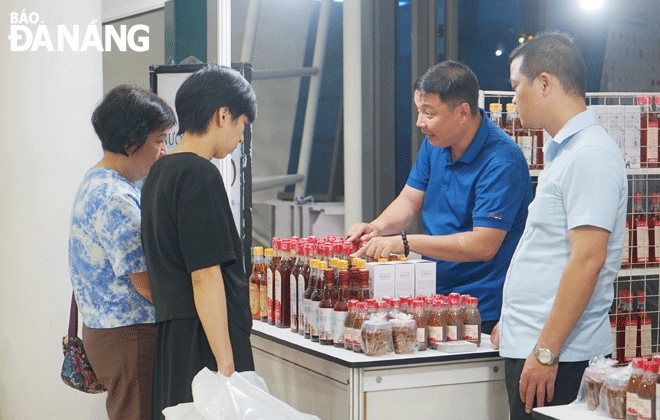 Collective brands contribute to improving competitiveness and enhancing product value. IN PHOTO: Tourists buy Nam O fish sauce products at the International East-West Economic Corridor (EWEC) Trade and Tourism Fair 2023. Photo: VAN HOANG