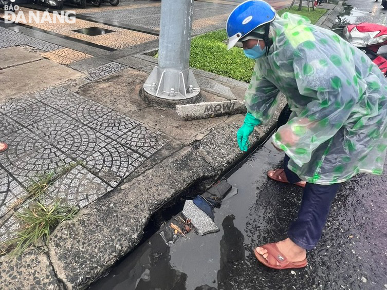 Công ty Thoát nước và xử lý nước thải Đà Nẵng đang huy động công nhân khơi thông các cửa thu nước mưa để phòng, chống ngập úng. Ảnh: HOÀNG HIỆP