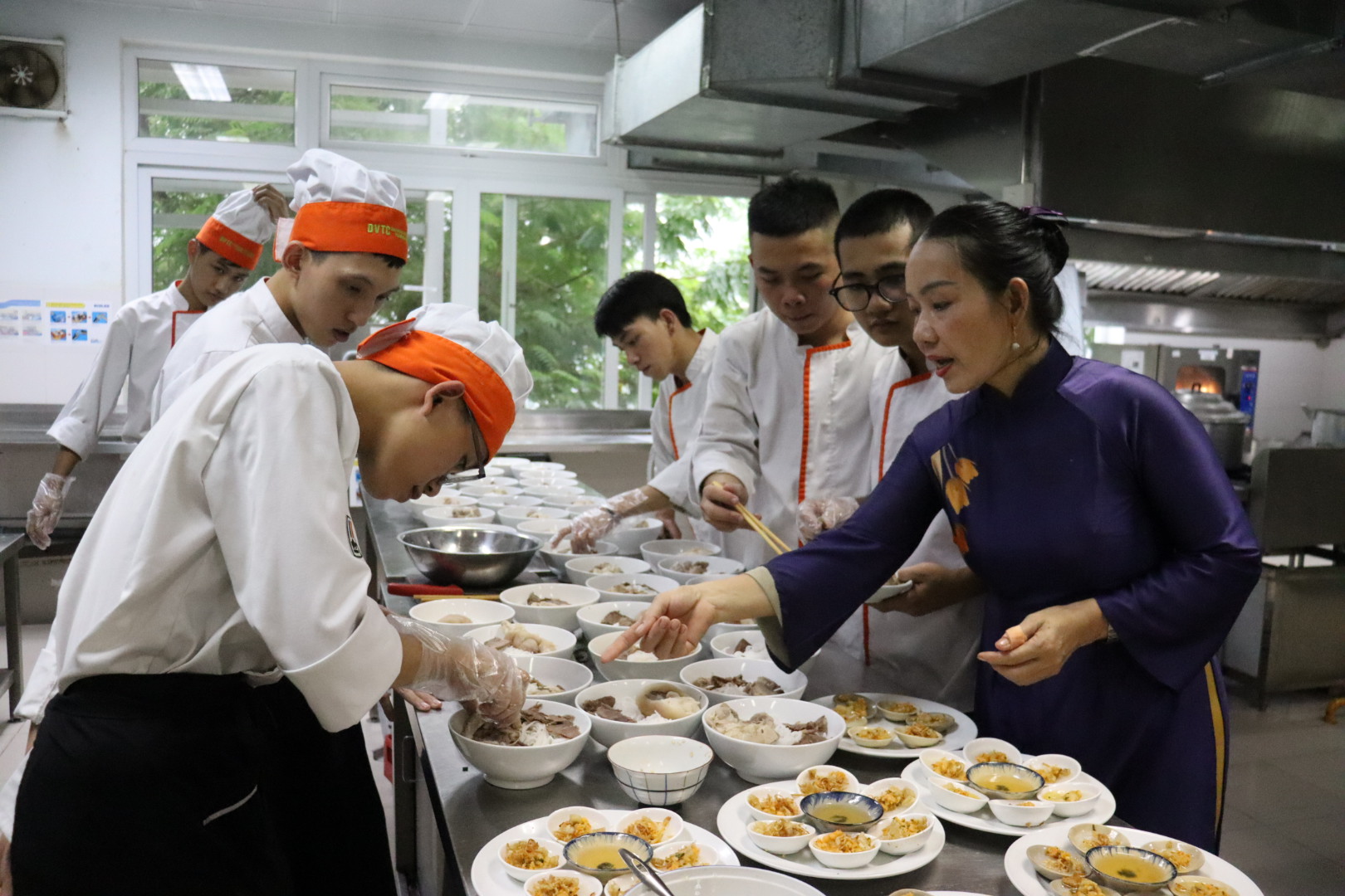 Culinary Artisan Hong Loan (right) guides and shares her experience in preparing Hue specialties with chefs. Photo: TRAN TRUC