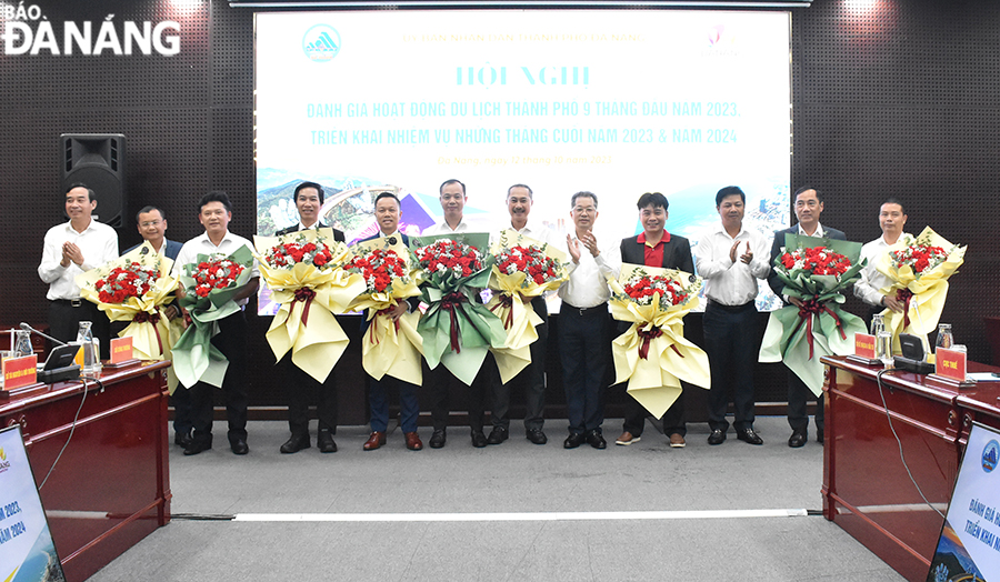 Secretary of the Da Nang Party Committee Nguyen Van Quang (5th, right), municipal Party Committee Deputy Secretary cum People's Council Chairman Luong Nguyen Minh Triet (3rd, right), Chairman of the City People's Committee Le Trung Chinh congratulate tourism businesses on the Viet Nam Entrepreneurs' Day (October 13). Photo: THU HA