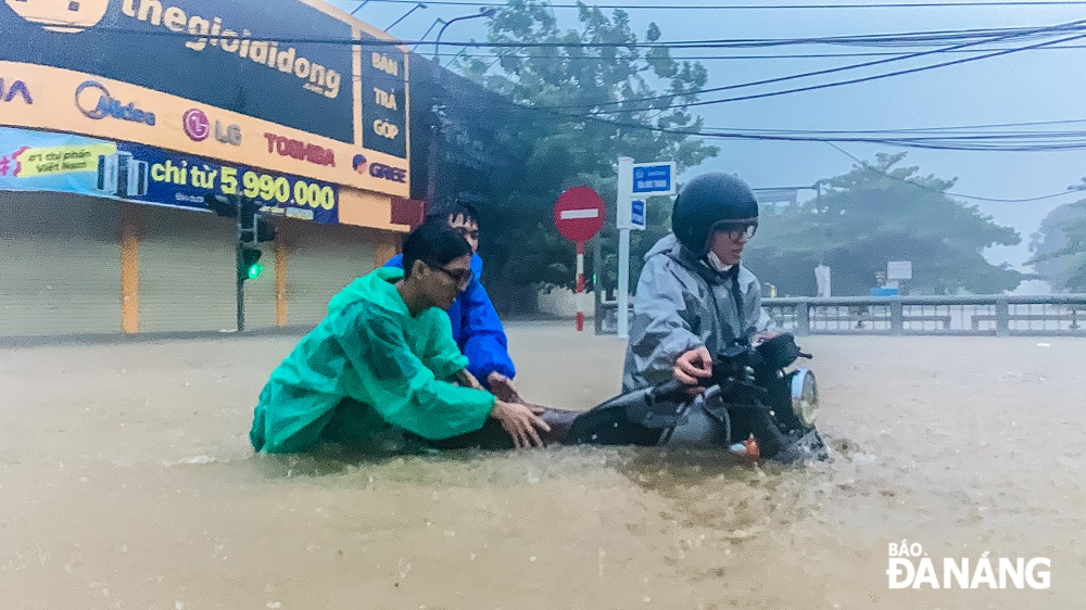 Các đoàn viên Đoàn TNCS Hồ Chí Minh phường Hòa An giúp đỡ người dân di dời phương tiện ra khỏi vùng ngập úng.