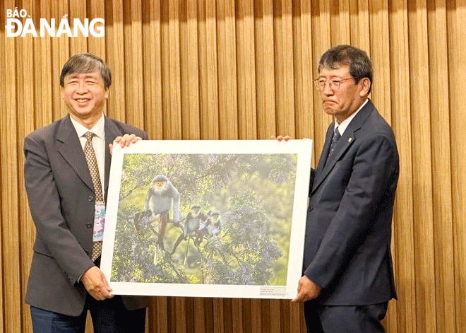 Chủ tịch Liên hiệp các Hội Văn học - Nghệ thuật thành phố Bùi Văn Tiếng (bên trái) thay mặt đoàn trao tặng các tác phẩm ảnh nghệ thuật cho thành phố Daegu trong chuyến giao lưu.  Ảnh: PV
