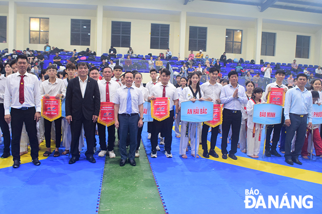 Deputy Director of the municipal Department of Culture and Sports Nguyen Trong Thao (front row, second left) and members of the organizing board present souvenir flags to participating clubs.