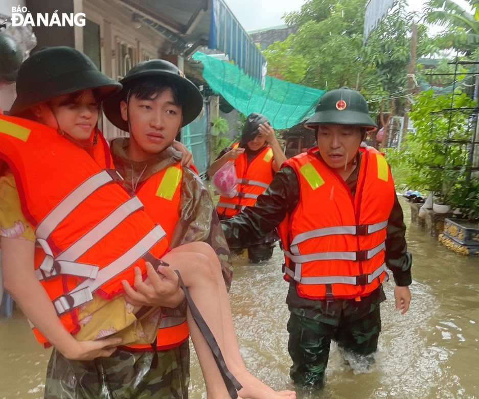 Cán bộ, chiến sĩ BĐBP thành phố di chuyển người dân khu vực thấp trũng tại phường Hòa Hiệp Bắc (quận Liên Chiểu) đến nơi an toàn vào sáng 14-10. Ảnh: B.V