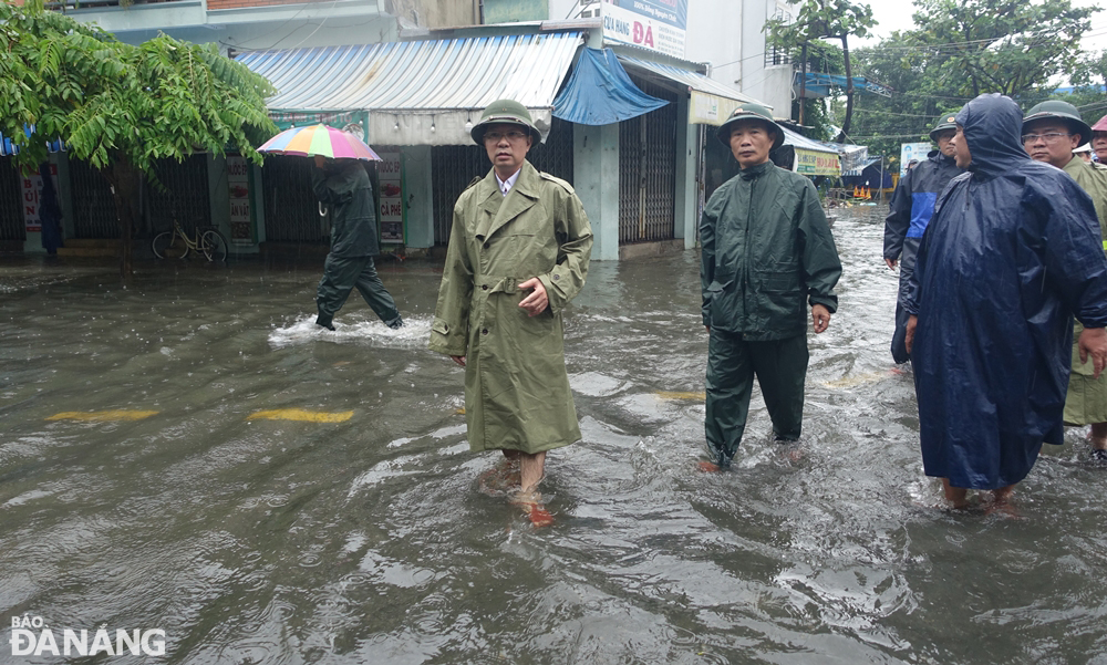 Bí thư Thành ủy Nguyễn Văn Quảng (trái) kiểm tra tại một điểm ngập úng ở đường Trần Cao Vân. Ảnh: HOÀNG HIỆP