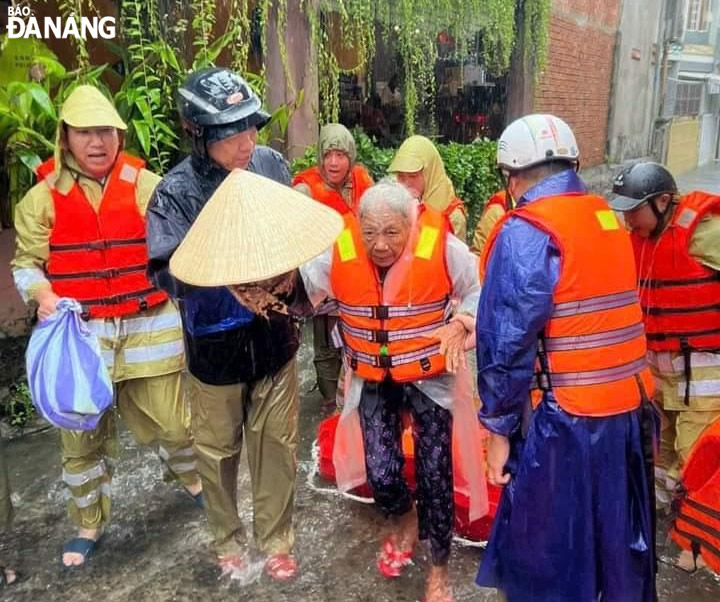 Cán bộ, chiến sĩ Công an quận Thanh Khê di chuyển người già sinh sống tại khu vực thấp trũng trên địa bàn quận đến nơi an toàn.