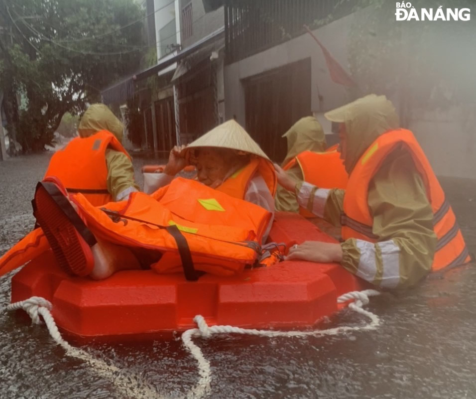 Cán bộ, chiến sĩ Công an quận Thanh Khê chủ động di chuyển những người trong vùng thấp trũng trên địa bàn đến nơi khô ráo.