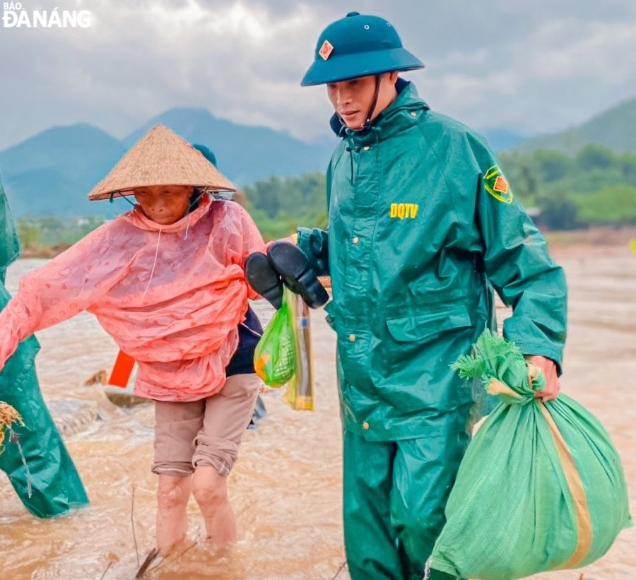 Lực lượng Dân quân xã Hòa Nhơn (huyện Hòa Vang) hỗ trợ người dân vùng ngập lụt đến nơi an toàn.