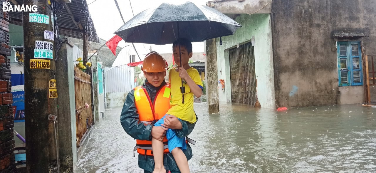 Lực lượng Dân quân phường Thanh Khê Tây (quận Thanh Khê) hỗ trợ người dân khu vực Khe Cạn bị ngập lụt đến nơi an toàn.